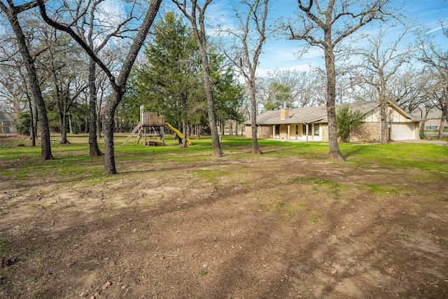 view of yard with a garage and a playground