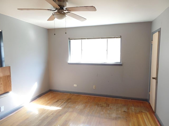 empty room with ceiling fan and hardwood / wood-style floors