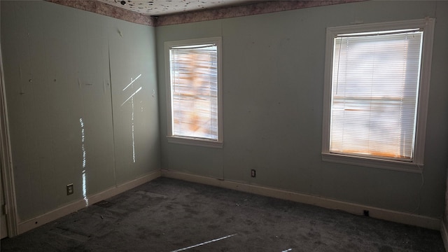 unfurnished room with dark colored carpet