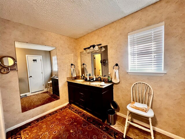 1030 Laurel Ln, Paris, TX 75460 - bathroom featuring a sink, double vanity, a textured ceiling, and baseboards