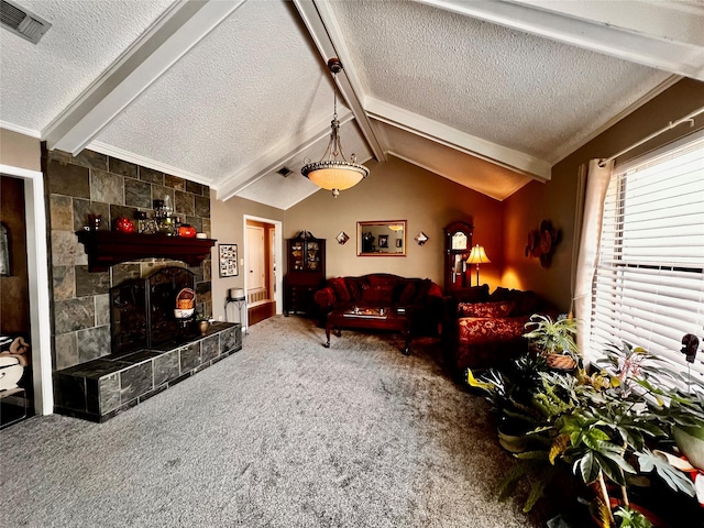 living room with lofted ceiling with beams, a tiled fireplace, carpet, and a textured ceiling