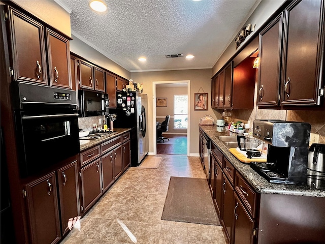 1030 Laurel Ln, Paris, TX 75460 - kitchen with a textured ceiling, dark brown cabinets, visible vents, backsplash, and black appliances