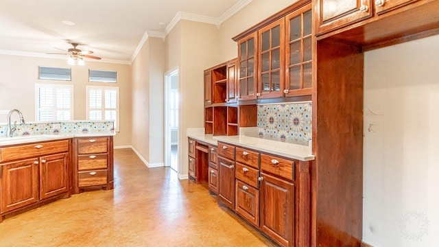 kitchen with backsplash, ceiling fan, ornamental molding, and sink