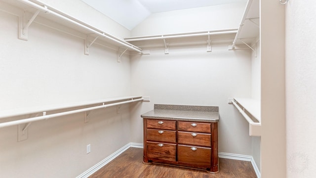 walk in closet featuring dark wood-type flooring and lofted ceiling