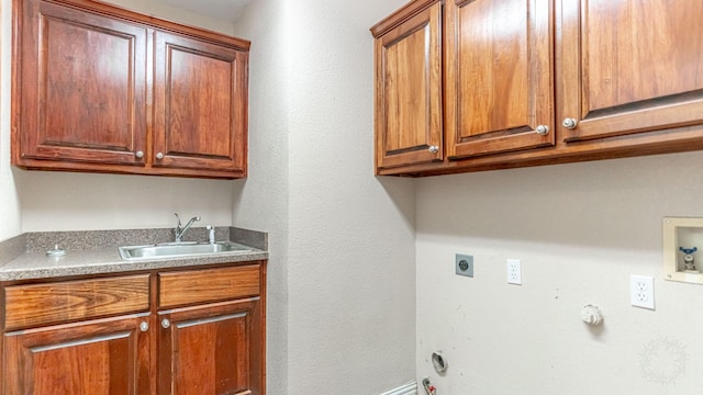 washroom featuring cabinets, washer hookup, hookup for an electric dryer, gas dryer hookup, and sink