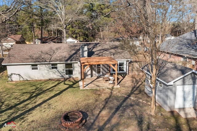 back of house featuring a pergola, a patio area, a lawn, and a fire pit