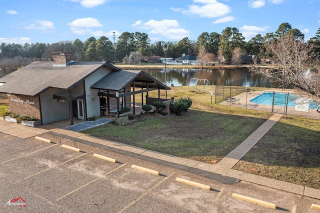 view of front of house with a front lawn, a water view, and a patio