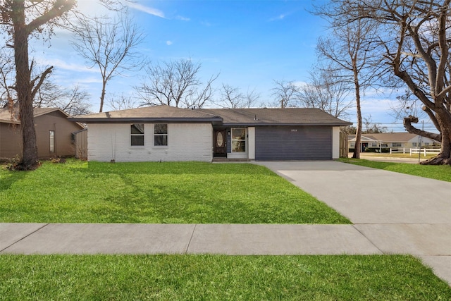 view of front of home with driveway, a front lawn, and brick siding