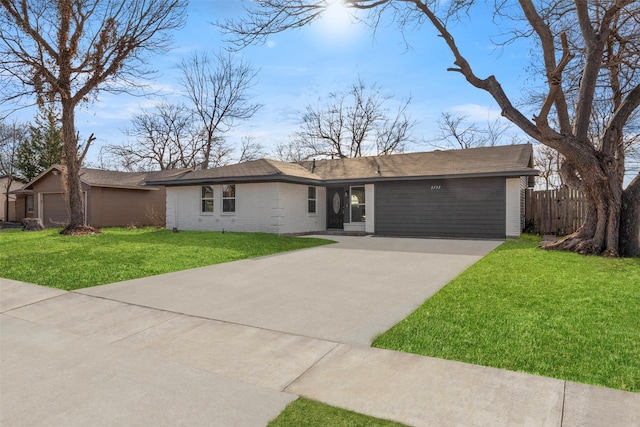 view of front of home featuring brick siding, driveway, a front lawn, and fence