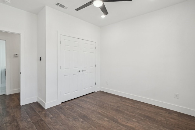 unfurnished bedroom with dark hardwood / wood-style floors, ceiling fan, and a closet