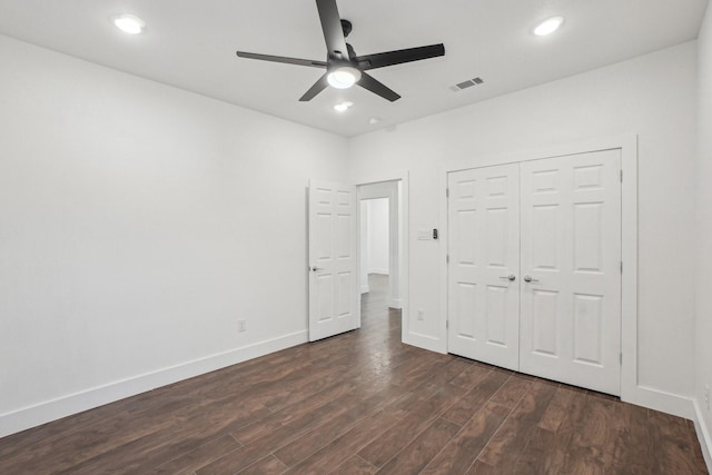 unfurnished bedroom featuring dark hardwood / wood-style flooring, a closet, and ceiling fan