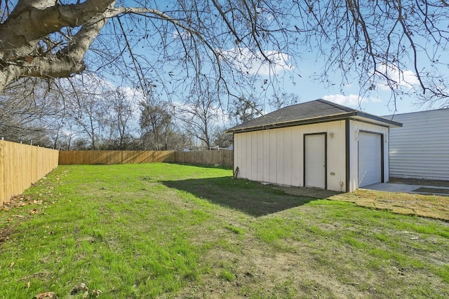 view of yard with a garage and an outbuilding