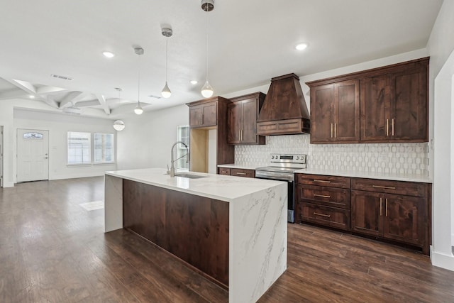 kitchen with sink, premium range hood, a center island with sink, decorative light fixtures, and stainless steel range with electric cooktop