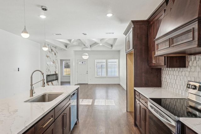 kitchen with pendant lighting, sink, appliances with stainless steel finishes, tasteful backsplash, and custom range hood