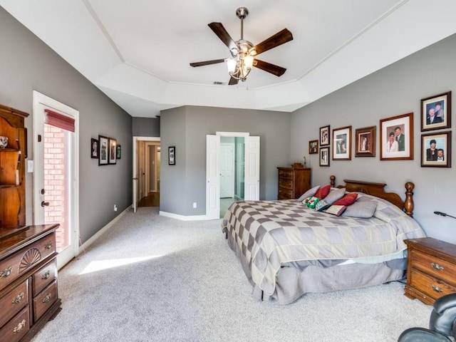 bedroom with light colored carpet, a raised ceiling, and ceiling fan