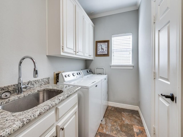 clothes washing area featuring washer and clothes dryer, crown molding, sink, and cabinets