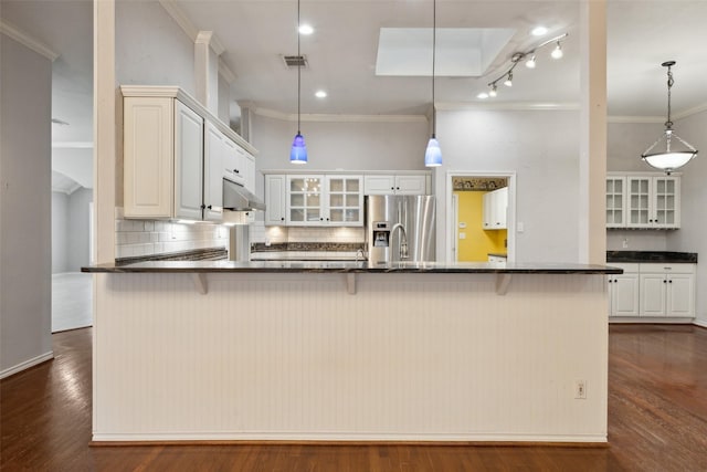 kitchen with hanging light fixtures, a large island with sink, and stainless steel refrigerator with ice dispenser