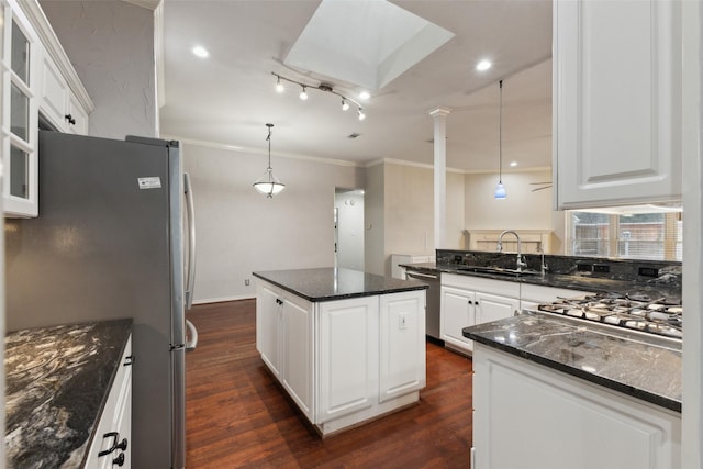 kitchen featuring sink, decorative light fixtures, white cabinetry, a center island, and appliances with stainless steel finishes