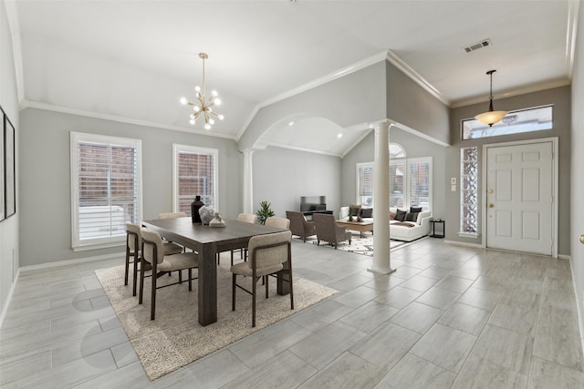 dining space featuring lofted ceiling, ornate columns, a chandelier, and plenty of natural light