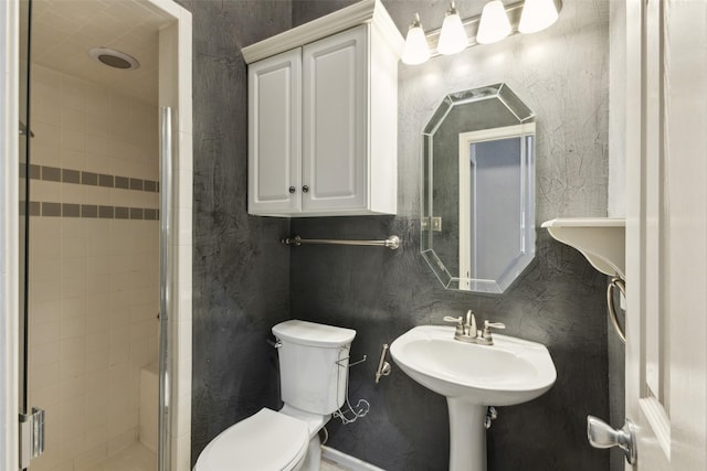 bathroom featuring toilet, walk in shower, and sink