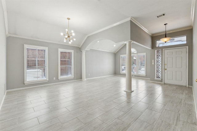 entrance foyer featuring a notable chandelier, crown molding, lofted ceiling, and decorative columns