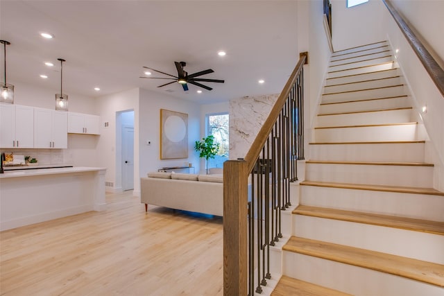 stairs with ceiling fan and wood-type flooring