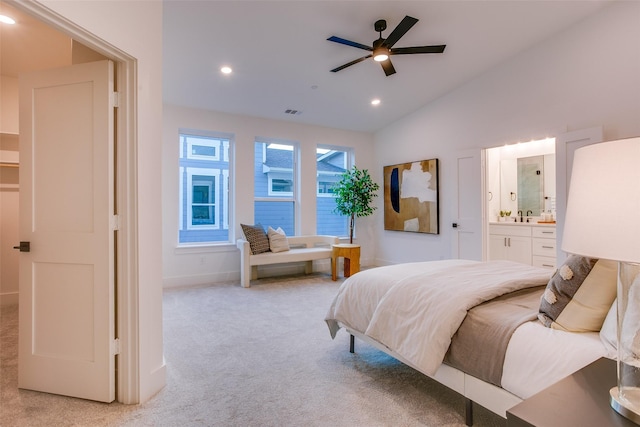 bedroom with connected bathroom, ceiling fan, light colored carpet, and lofted ceiling