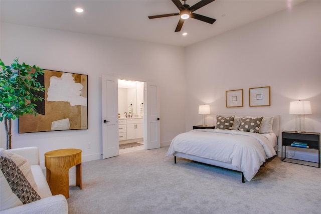 bedroom with ceiling fan, light colored carpet, sink, and connected bathroom