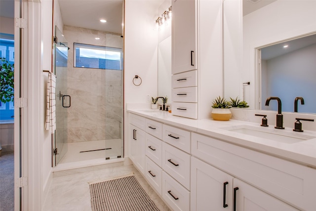 bathroom featuring a shower with door and vanity