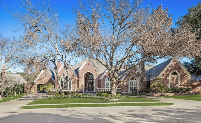 tudor-style house featuring a front yard