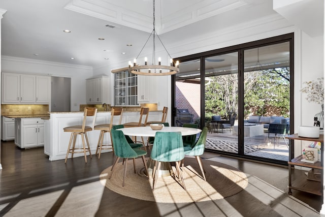 dining room featuring dark hardwood / wood-style flooring, crown molding, and an inviting chandelier