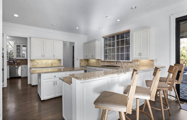 kitchen with dishwasher, white cabinets, a kitchen island, and sink