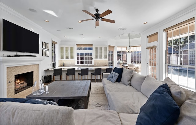 living room featuring hardwood / wood-style floors, ceiling fan, and crown molding