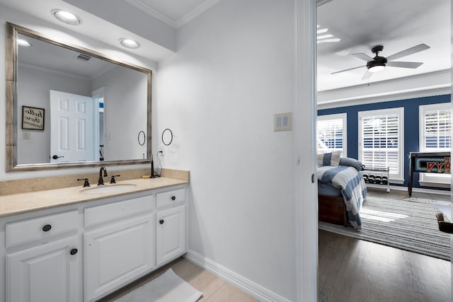 bathroom with ceiling fan, crown molding, vanity, and wood-type flooring