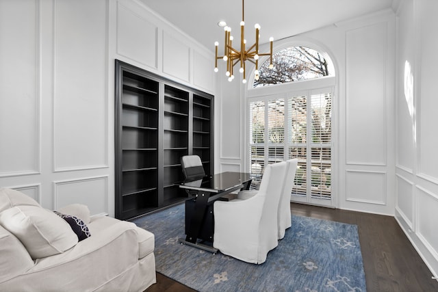 home office with dark wood-type flooring and a notable chandelier