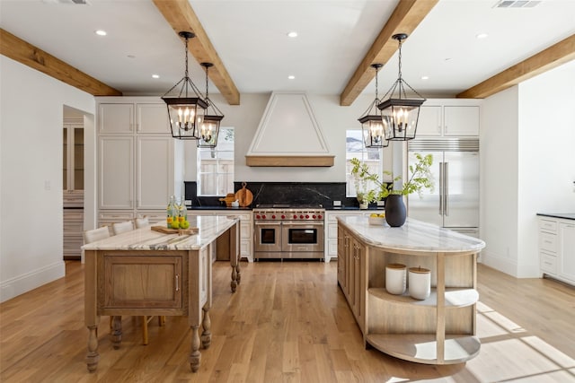 kitchen featuring a kitchen island, high quality appliances, and hanging light fixtures