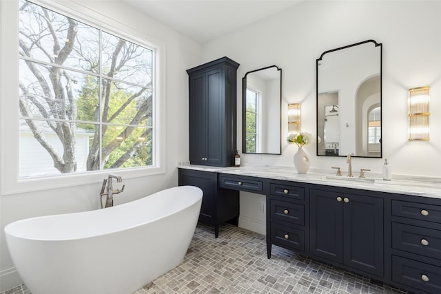 bathroom with a washtub and vanity