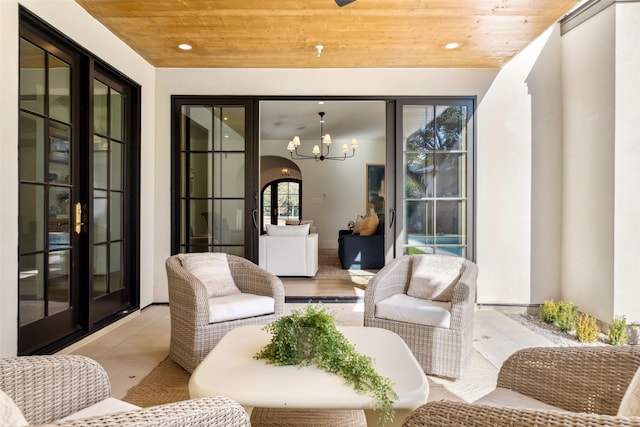 sunroom / solarium with wood ceiling, french doors, and a chandelier