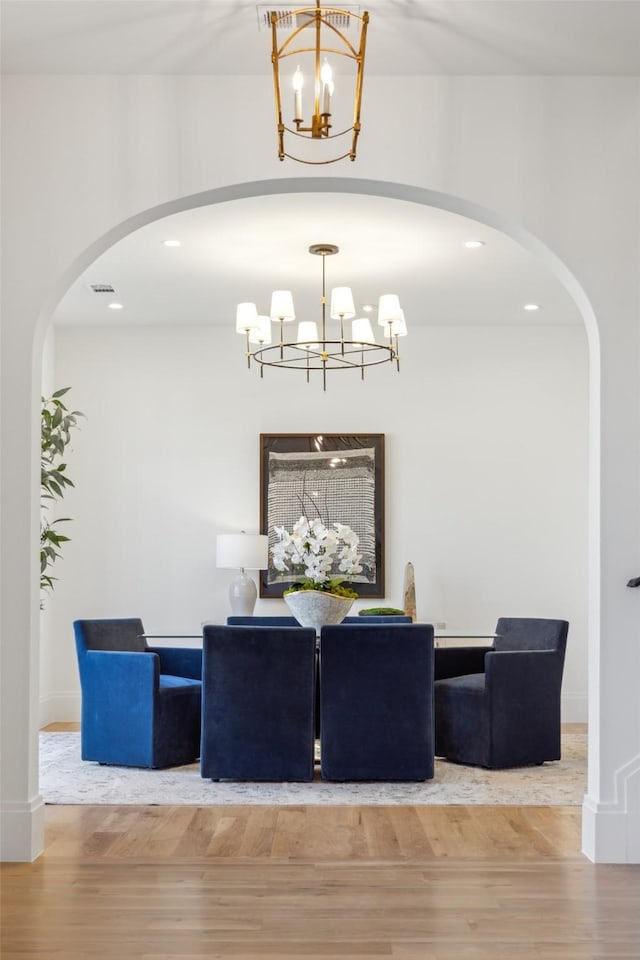 dining room with light hardwood / wood-style floors and a notable chandelier