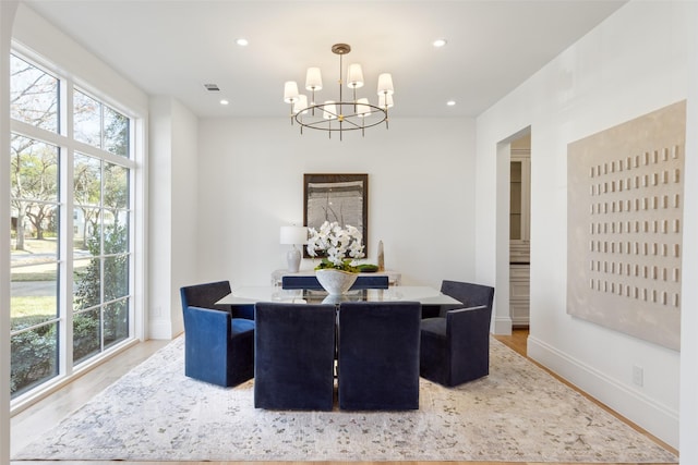 dining space featuring wood-type flooring and an inviting chandelier