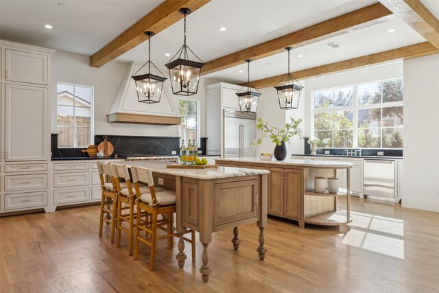 kitchen with white cabinetry, a large island, and decorative light fixtures