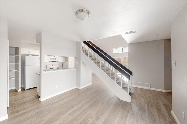 staircase with hardwood / wood-style floors