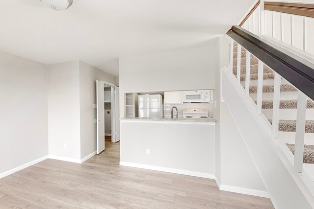 stairway featuring wood-type flooring and sink