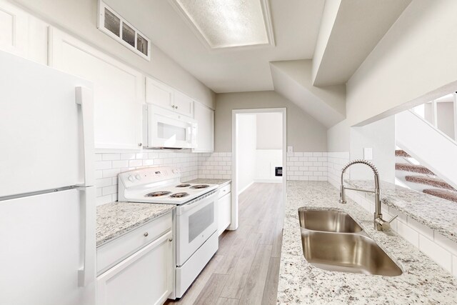 kitchen with white cabinetry, light stone countertops, white appliances, and sink