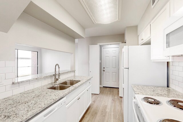 kitchen with backsplash, white cabinetry, white appliances, and sink