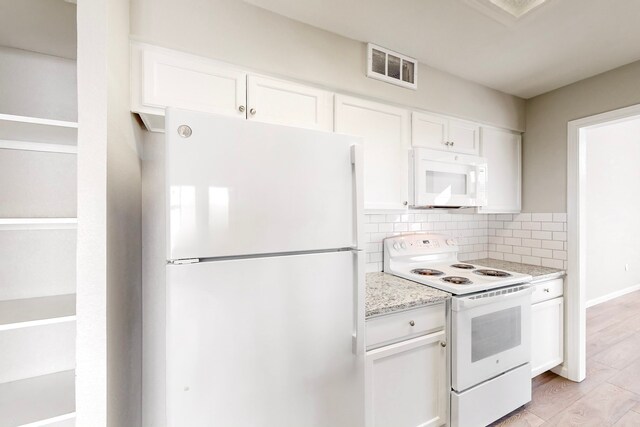 kitchen featuring white appliances, white cabinets, light hardwood / wood-style flooring, decorative backsplash, and light stone countertops