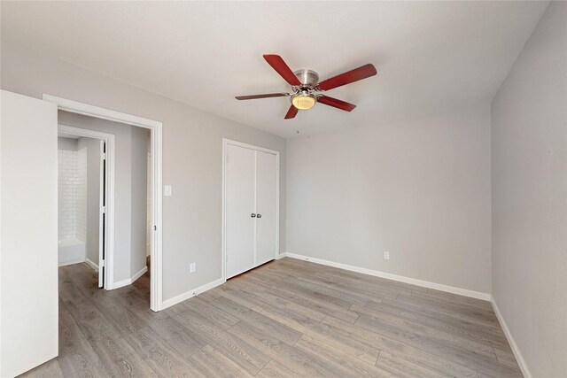 unfurnished bedroom featuring ceiling fan, a closet, and hardwood / wood-style flooring