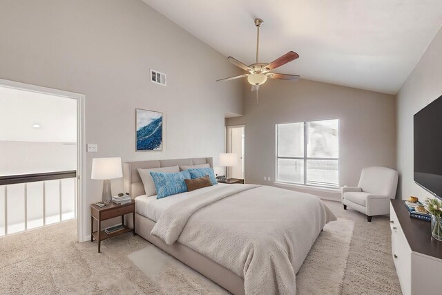 carpeted bedroom with ceiling fan and high vaulted ceiling