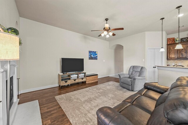 living room with dark hardwood / wood-style flooring and ceiling fan