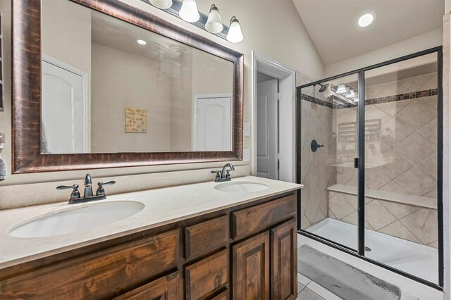 bathroom featuring vanity, an enclosed shower, and lofted ceiling